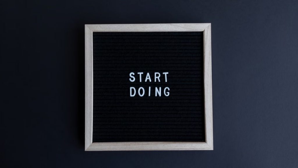 Black letter board with the motivational phrase 'Start Doing' in white text on a gray background.