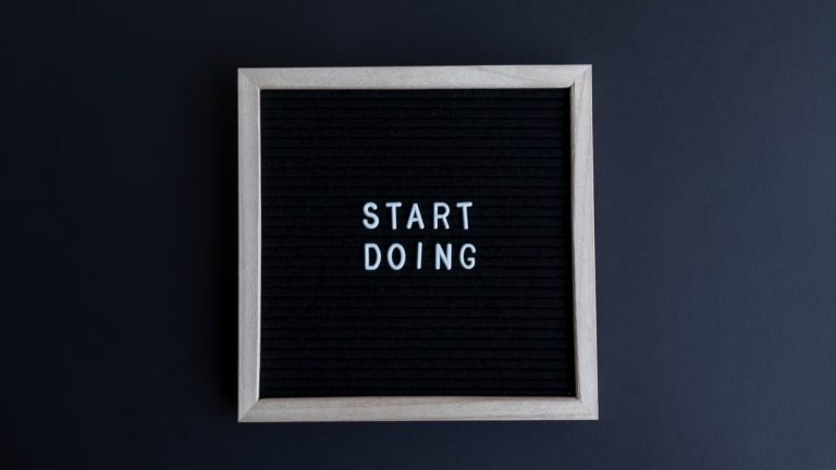 Black letter board with the motivational phrase 'Start Doing' in white text on a gray background.